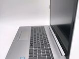a silver laptop with a black keyboard on a white surface