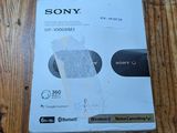 La boîte du chargeur sans fil Sony se trouve sur le parquet.