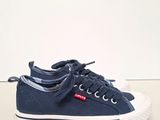 a close up of a pair of blue sneakers on a white surface