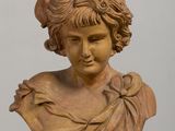 a bust of a woman with a hat on top of a table