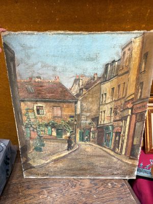 une photo d'un tableau posé sur une table à côté d'une valise
