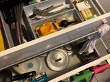 a kitchen drawer full of cleaning supplies in the kitchen