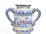 a blue and white vase with a handle on a stand