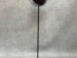 une image représentant une lampe posée sur un pied devant un mur