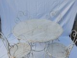 a white table and four chairs sitting on a white sheet