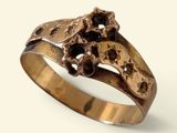 une image représentant une bague en or sertie de pierres noires