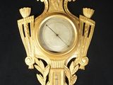 une horloge en or sur le mur avec un oiseau dessus