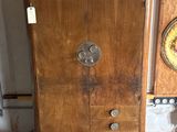 a wooden cabinet that has a clock on top of it
