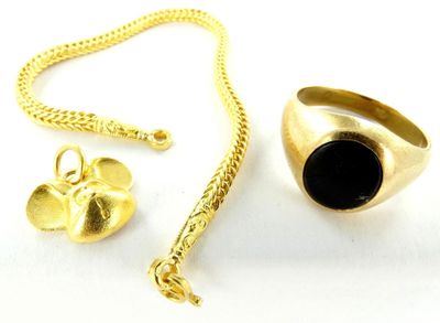 une image représentant une bague en or, une pierre noire et une chaîne en or