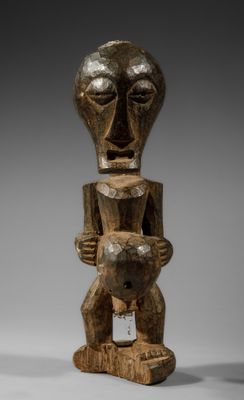 une statue en bois représentant un homme tenant un bébé dans ses bras