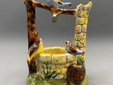 deux oiseaux perchés au sommet d'une fontaine