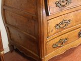a wooden chest of drawers in the corner of a room