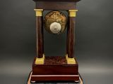 a clock that is sitting on top of a wooden stand