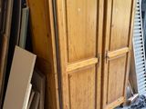 a wooden cabinet that is sitting next to a pile of wood