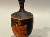a black and red vase sitting on a white surface