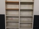 une bibliothèque blanche à deux étagères, placée dans un coin