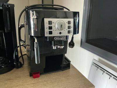 une machine à café posée sur un plan de travail devant un téléviseur à écran plat