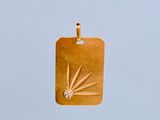 un pendentif en or orné d'un diamant, suspendu à un cordon