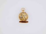 a close up of a gold pocket watch on a white surface