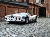 a toy car sitting on a cobblestone road in front of a brick building