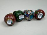 four different colored vases sitting on top of a white surface