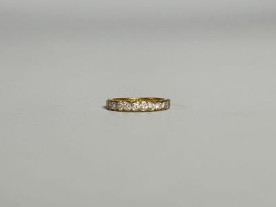 une bague en or jaune sertie de cinq diamants sur une surface blanche