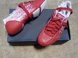 une paire de chaussures rouges et blanches posée sur une boîte