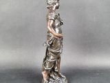 a silver statue of a woman with a flower in her hand