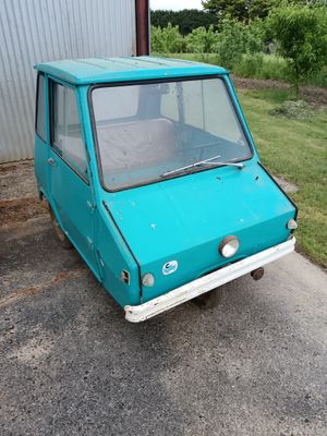 a small blue car that is parked in front of a building