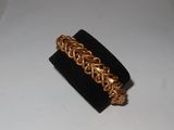 a close up of a gold bracelet on a black ring