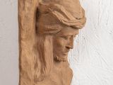 plaster sculpture of a woman ' s head on a wall