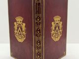 un vieux livre surmonté d'une couronne, posé sur une table