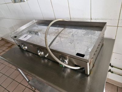 stainless steel counter top with a gas stove on it in a kitchen
