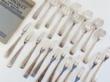 many forks and spoons laid out on the table