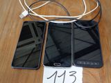 trois téléphones portables posés sur une table, avec une étiquette de prix accrochée dessus