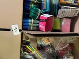 two boxes with pens and pencils in them on a shelf