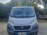 the front of a silver van parked in a parking lot