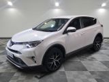 une Toyota RAV blanche garée sur un sol à damier