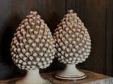 two decorative pine cones sitting on a marble table