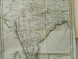 an old map of india in a book on a table