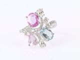 a close up of a ring with pink, blue and white stones