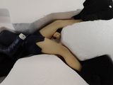 a doll laying on a bed with a stuffed animal