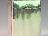 a silver cigarette case sitting on a white surface