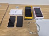 a table with a phone, headphones, and a charger on it