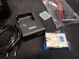 the contents of a camera and other electronics are laid out on the floor