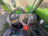 a steering wheel and dashboard of a green tractor