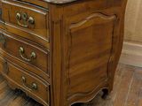 a small wooden chest of drawers on a hard wood floor