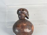a small wooden duck sitting in a clear box