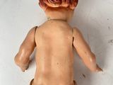 a small doll that is sitting on a white surface