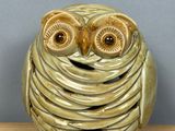 a ceramic owl sitting on top of a wooden table
